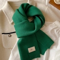 Close-up of dark green knitted scarf with vertical rib texture on a wool coat - Forest Green