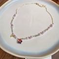 Elegant beaded flower necklace with purple pearls and gold butterfly charm accessory - Gold Multicolor