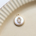 Detail of round gold-plated pendant with mother of pearl and zircon letter Q on ceramic - Q Round