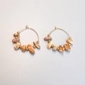 Detail of bohemian gold hoop earrings featuring irregular natural stones and metal beads - Picture Jasper