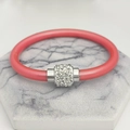 Dettaglio del bracciale in silicone rosa corallo con cilindro argento e strass incastonati - Rosa
