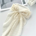 Crème haarstrik met witte polkadots en lange linten in een elegante modieuze stijl - crème