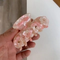Detailed macro of a pink marble acetate hair claw clip with gold rhinestone flowers - Sakura Pink