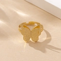 Nahaufnahme eines goldenen Schmetterlingsrings mit matten Flügeln und verstellbarem Band - Gold