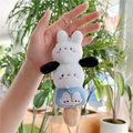Dettaglio di un portachiavi in peluche con coniglio, viso tondo e simpatico pinguino blu - Catena Pendente / Bianco