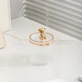 Luxuriöser Kosmetik-Organizer mit vertikalen Streifen und goldenem Bären-Deckelgriff - Transparent mit goldenem Bären