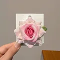Pink gradient silk flower hair clip with green leaves on a white card display - Pink Rose Hair Clip