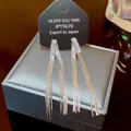 Macro shot of 925 sterling silver long tassel earrings with sparkling zircon stones - Silver Rectangular Zirconia Tassel