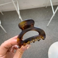 Close-up of tortoise shell resin hair claw clip showing glossy finish and teeth detail - Matte Light Tortoise