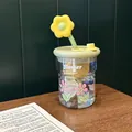 Detailed view of floral glass tumbler with sunflower straw topper and green lid on desk - Green