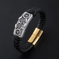 Detail of black braided leather bracelet featuring a silver motorcycle skull and magnetic clasp - Gold