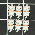 Nahaufnahme von weißen Katzenanhängern mit orangen Halsbändern für DIY-Schmuck - Weiß
