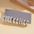Dettaglio di dieci orecchini a cerchio argentati con varie trame e finiture diverse - Argento (Set da 10 pezzi)