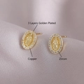 Golden oval Virgin Mary stud earrings with zircon inlay on a grey silk background - Gold Plated Virgin Mary Zirconia (EM07-9)