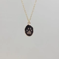 Detail of gold stainless steel necklace with black oval paw print pendant and O-chain - Obsidian-Paw Print