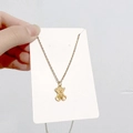 Détail du collier avec pendentif ours en or 18 carats sur sa carte support - Ours A
