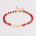 Dettaglio del bracciale con perline rosse, cuori intrecciati dorati e chiusura a moschettone - Bracciale Doppio Cuore con Perline Rosse