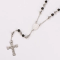 Macro detail of a silver rosary necklace with black beads and a silver Jesus cross pendant - Two-tone Black