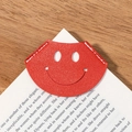 Red smiley face leather corner bookmark for books with detailed white stitching - Red