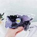 Detail of colorful hair ties in a floral zipper bag for babies and children - Black Daisy Bag