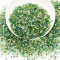 Detailed top view of bulk green square glass beads in a white bowl for DIY jewelry - Green System