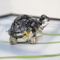 Detailed view of turtle figurine made of white spotted stone with gold foil accents - Snowflake Obsidian + Gold Foil