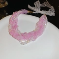 Detail einer rosa Perlenkette mit weißen Perlen und zarten Spitzenbändern zum Binden - Lila