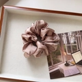 Detail view of pink satin scrunchie with silky luster in a minimalist wooden tray - Medium / Light Coffee