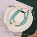 Detail of blue lapis bead bracelet set with shell accents on decorative white tray - Style 18-Double Shell Bracelet
