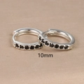 Close-up of 10mm silver hoop earrings with black zircon stones on a textured surface - 10mm Silver Black Rhinestone (E1014-10mm)