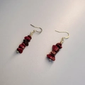 Macro detail of Bohemian handmade gold hook earrings with natural red crystal stone beads - Red Jasper