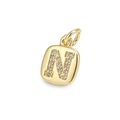 Close-up of golden letter N pendant with sparkling zircon inlays and small metal ring - Letter N