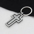 Detail shot of the rotating vintage silver metal cross keychain on dual-tone background - Antique Silver