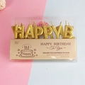 Close-up of gold Happy Birthday letter candles in elegant English window packaging - Luxury Gold