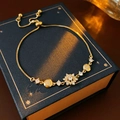 Dettaglio del bracciale regolabile in oro con cuore di zircone su una scatola regalo - Bracciale Scorrevole Disco Floreale (5#) / Oro