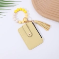 Detail of yellow pebbled leather card holder with silicone bead bracelet and tassel - Yellow