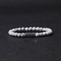 Vue macro de perles en pierre marbrée de 6mm et breloque mantra argentée sur bracelet - Bracelet Howlite Blanche