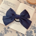 French vintage navy blue satin bow hair scrunchie placed on an open book page - Bow Scrunchie / Navy Blue