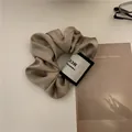 Chouchou en satin champagne avec étiquette tissée MCC et texture plissée élégante - Chouchou Satiné Gris avec Étiquette