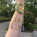 Detail of moon sun catcher with green crystals, golden butterfly, and prism pendants - Green Aventurine
