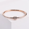 Brazalete de acero inoxidable en oro rosa pulido con cristales pavé y diseño triple - Oro rosa