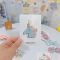 Close-up of glittery blue unicorn hair clip with gold horn on a handmade display card - Light Blue Unicorn