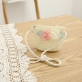 Détail d'un sac bandoulière en paille pour enfant avec fleurs roses et bandoulière en corde - Sac / Crème