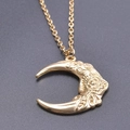 Macro shot of gold crescent moon pendant featuring intricate flower engravings on chain - Gold Color + Necklace Chain