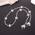 Detail of white pearl strap with bow accents and metal hooks on a dark grey surface - Pearl Bowknot Style (K1239)