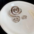 Detail von silbernem Spiralarmreif und Ohrringen auf weißem Keramiktablett - Armreif Und Ring Zweiteiliges Set / Silber