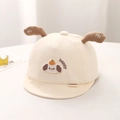 Detail van de katoenen babycap met schattige hondenoren en happy borduursel op zachte stof - 44cm 3-12 Maanden / Geel