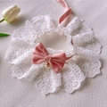 Summer cat lace collar with pink bow and pearl pendant on white textured surface - Pink