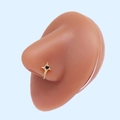 Close-up of golden cross nose stud with black heart stone on flesh-toned model - Gold Cross Black Heart (#11)