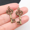 Due ciondoli a chiave a forma di cuore in bronzo antico mostrati per la taglia - Chiave a Fiore in Bronzo Antico 12x28mm